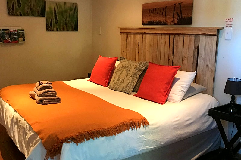 Honey Badger room with rustic wood headboard and warm decor