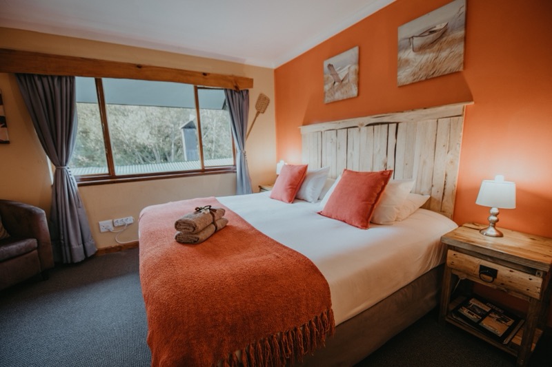 Kingfisher room with warm orange walls and king bed