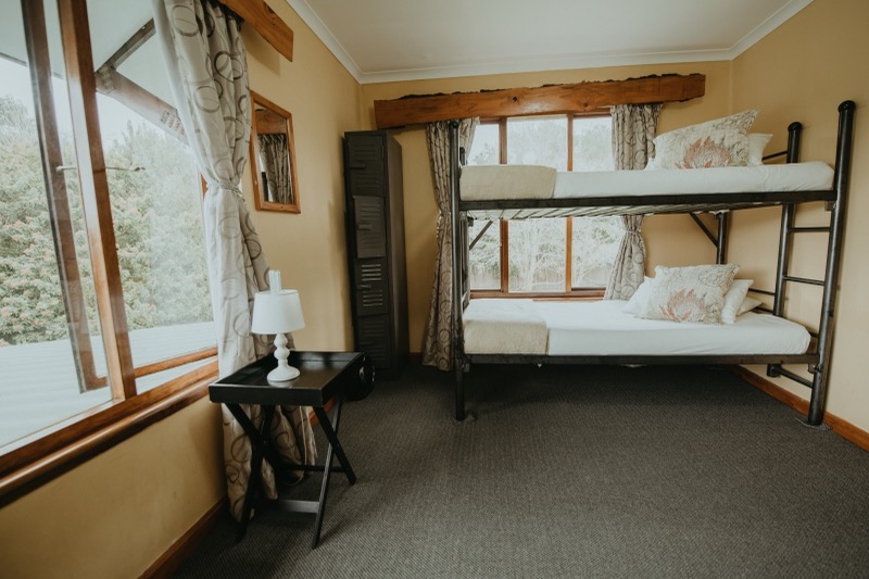 Evergreen dorm with bunk beds and forest views